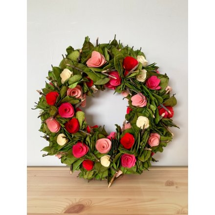 A beautiful decorated wreath with an added wooden rose feature 