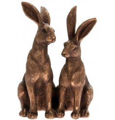 A smooth and finely finished decorative ornament of two sitting hares in a bronzed tone 