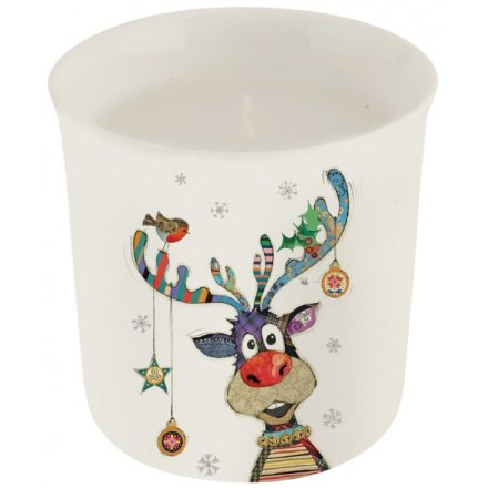 A Christmas candle with a colourful and quirky patchwork Reindeer illustration