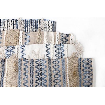 An assortment of 4 woven fabric hanging wall rugs, each set with a cream and blue toned tassel decal 