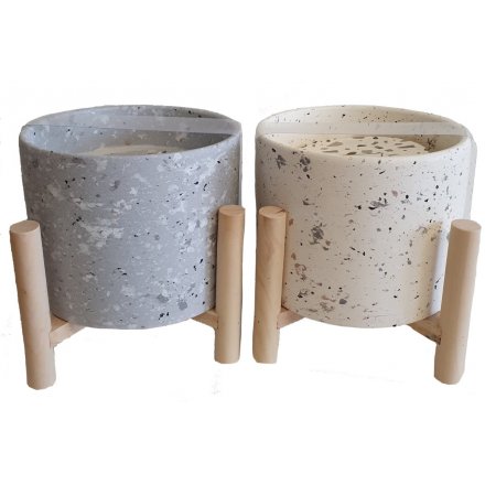   A mix of grey and mink toned Terrazzo candle pots on wooden legs
