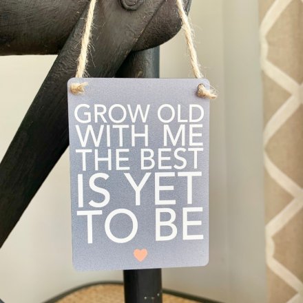 A sentimental little hanging metal sign with a scripted text quote and neutral grey base done 