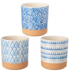 An assortment of small ceramic pots each featuring a striking blue patterned decal and terracotta toned base colour 