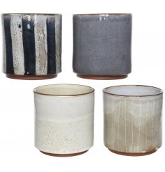 A mix of 4 blue and cream terracotta planters. Each has a rustic and stylish decorative pattern 