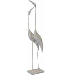 A large garden sculpture with two posed heron birds. Each has a rustic finish and is set upon a wooden base.