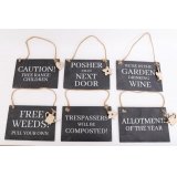 A quirky mix of slate plaques, each decorated with a bold gardening text decal and hanging wooden charm 