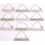 A wide assortment of sage green and white toned hanging plaques,