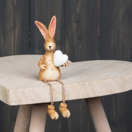 A cute little shelf sitting bunny ornament complete with a white heart and dangly legs 