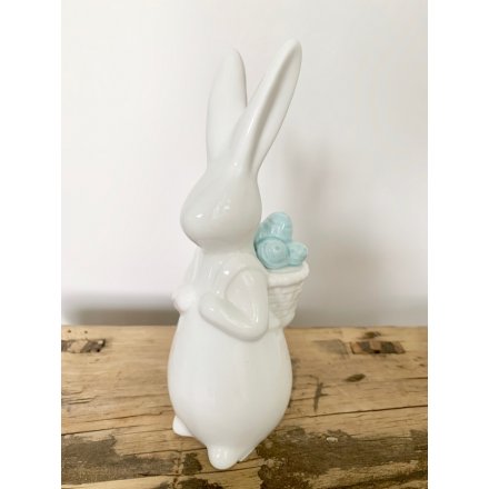 A charming Spring rabbit ornament with a beautifully detailed basket full of pastel blue eggs.