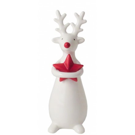 A small standing ceramic reindeer holding onto a festive red star 