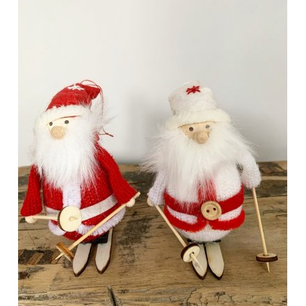 Pair of skiing santa figures in complementary knitted outfits, boxed for transport