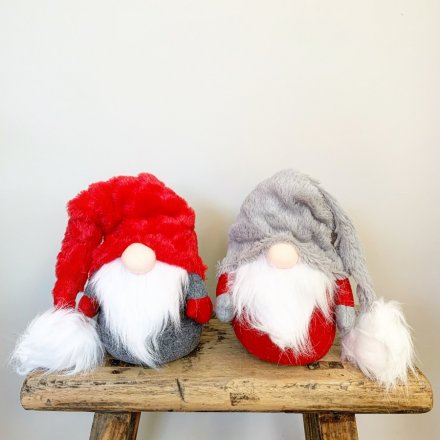 A mix of 2 grey and red sitting gonk decorations with soft pointed hats and faux fur beards.