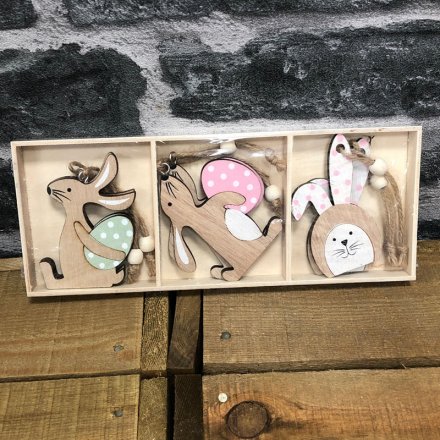 A set of 6 rustic wooden rabbit decorations in 3 assorted designs. Key features include polkadot eggs and bunny ears. 