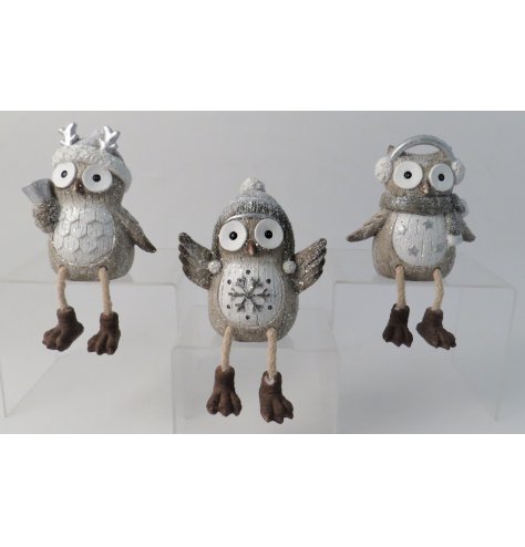Wide eyes sitting owl decorations in tones of white and silver with a dusting of glitter.