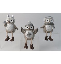 An assortment of 3 posed owl decorations each set with dangly legs and their own festive styles 