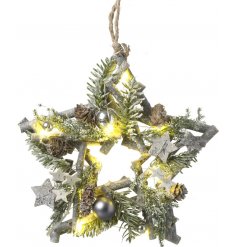 A Twig Star entwined with warm glowing LED Lights and decorated with woodland foliage and extras 