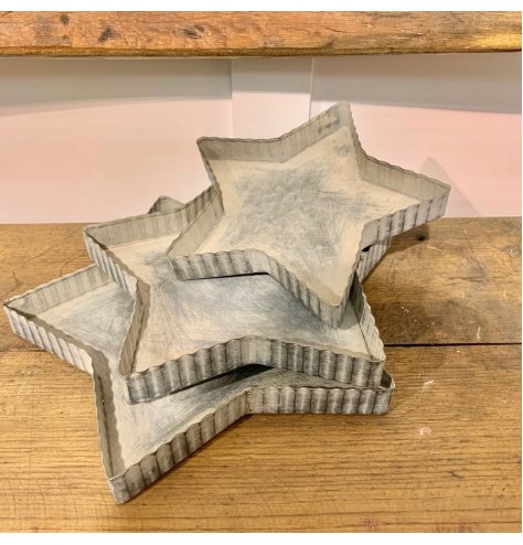 An assorted sized set of star shaped metal trays with a ridged edge 