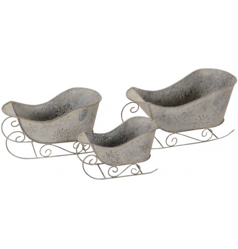 A set of 3 rustic sleighs decorated with a variety of embossed snowflakes.