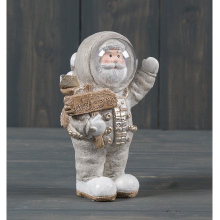 A small ceramic Santa dressed up as an astronaut, complete with gold trimmings and a sprinkle of glitter 