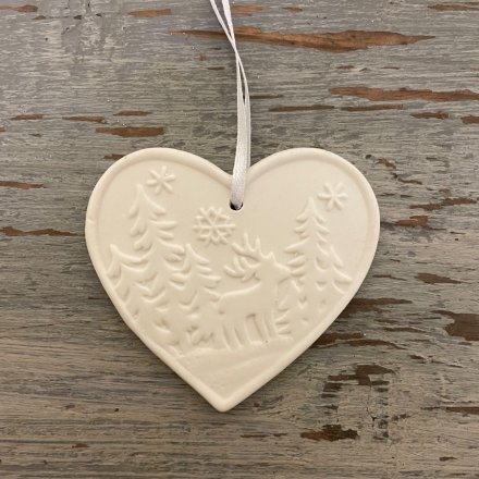  A small hanging ceramic heart decorated with a woodland scene 
