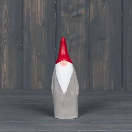   A tall standing concrete Gnome with a pointed red hat 