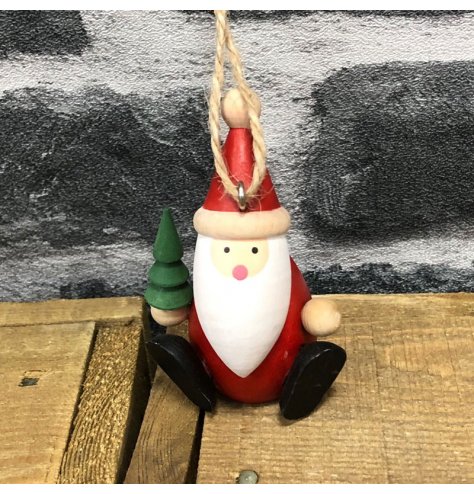 A small hanging decorative santa covered with traditional festive tones 