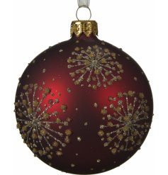 A luxe matte red bauble covered with a glittery gold and silver starburst decal