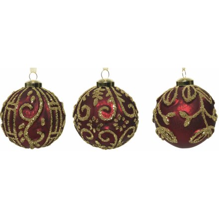 An assortment of mercury splash ox-blood red glass baubles, each beautifully decorated with a golden bead design 