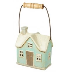 A small ceramic T-light holder in a house shape with an added wooden carry handle 