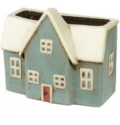 A decorative ceramic planter featuring a house inspired decal 