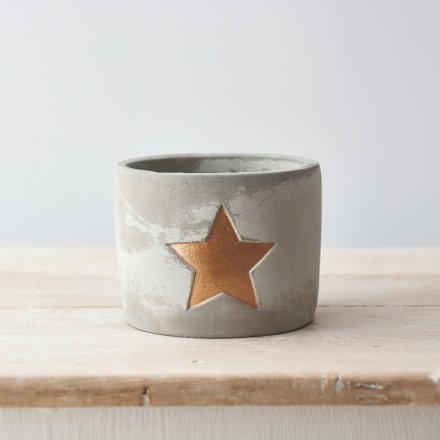 A rustic cement planter with a gold painted star. A rough luxe decorative accessory for the home.