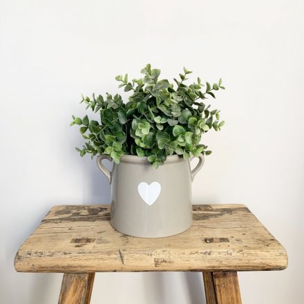 A stylish grey ceramic pot with twin ears. Decorated with a simple white heart design.