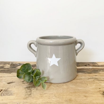 A chic grey pot with ears. Decorated with a simple white star design.