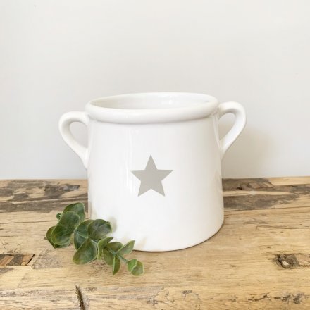 A classic white ceramic pot with ears. Decorated with a simple grey star design.