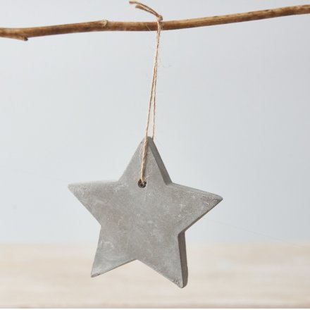 A hanging cement star decoration with jute string. A rustic item with a distressed finish.