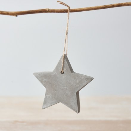 A rustic cement star decoration with a jute string hanger.