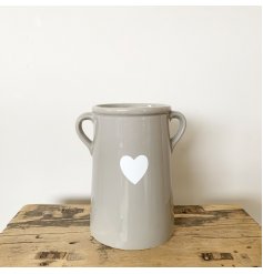A beautifully simple ceramic vase in grey. Complete with a white heart shaped decal and small handles.