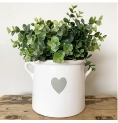 A beautifully simple white ceramic pot with a grey heart design and twin handles.