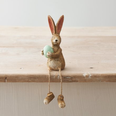 A unique shelf sitting rabbit decoration, complete with pointed ears, a green dotty egg and rustic dangling legs.