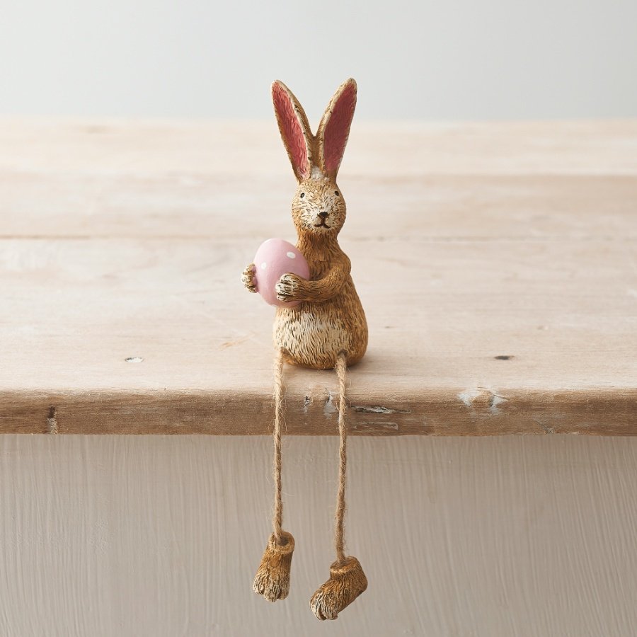 A rustic and wonderfully charming shelf sitting rabbit decoration, complete with a pink polka dot egg.