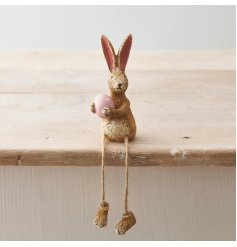 A rustic and wonderfully charming shelf sitting rabbit decoration, complete with a pink polka dot egg.