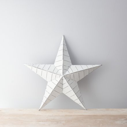 A vintage inspired white and black metal barn star with ridges and a distressed finish.