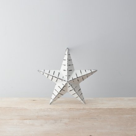 A vintage inspired white metal barn star with black ridges and a distressed finish.