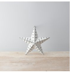 A rustic white metal barn star with ridges and a distressed finish.