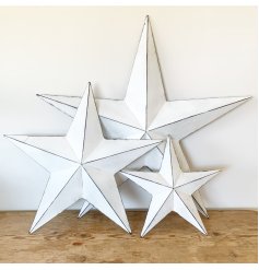A vintage inspired white metal barn star with a distressed finish and hook to hang.