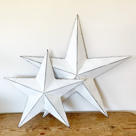 A rustic white metal barn star with a distressed finish. 