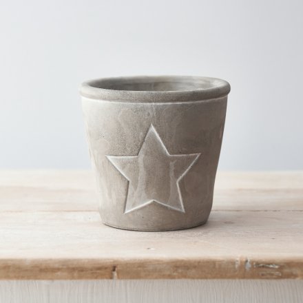 A rustic cement planter with a distressed painted finish and star design.