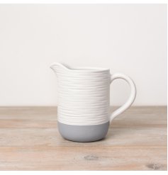 A rustic white and grey jug with a ribbed surface texture, creating a unique handmade feel.