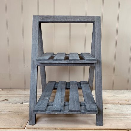 A natural wooden 2 tiered Display Shelf featuring an overly distressed grey washed tone 