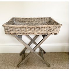 A rustic wicker tray table with a grey washed distressed finish. 